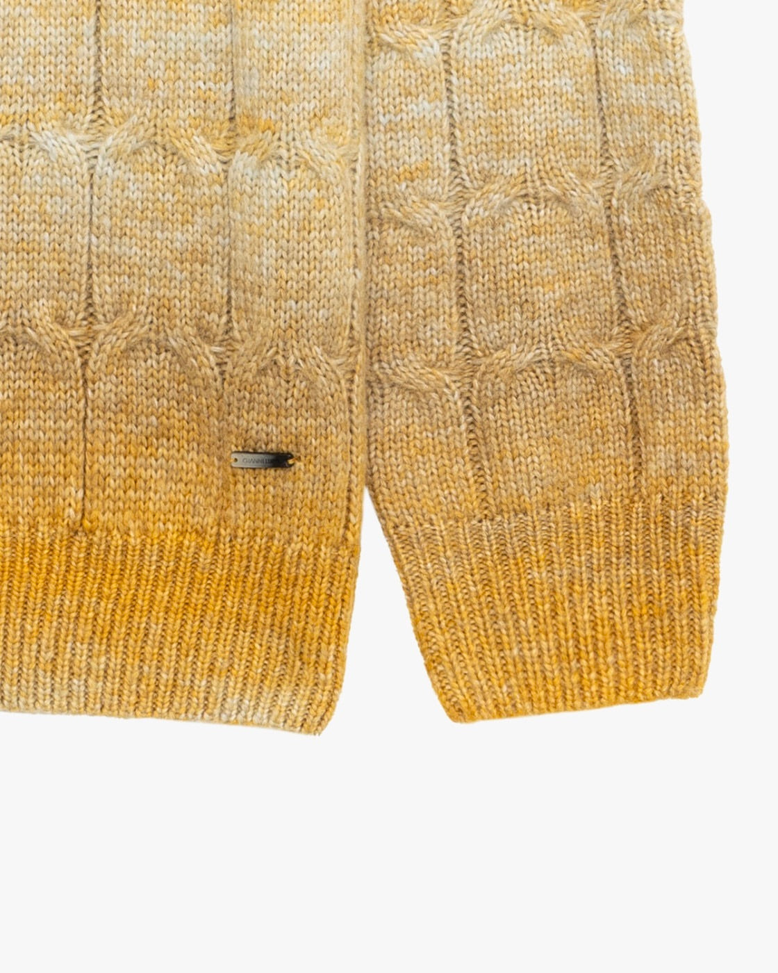 Dettaglio lavorazione a trecce e fondo a costine del maglione giallo