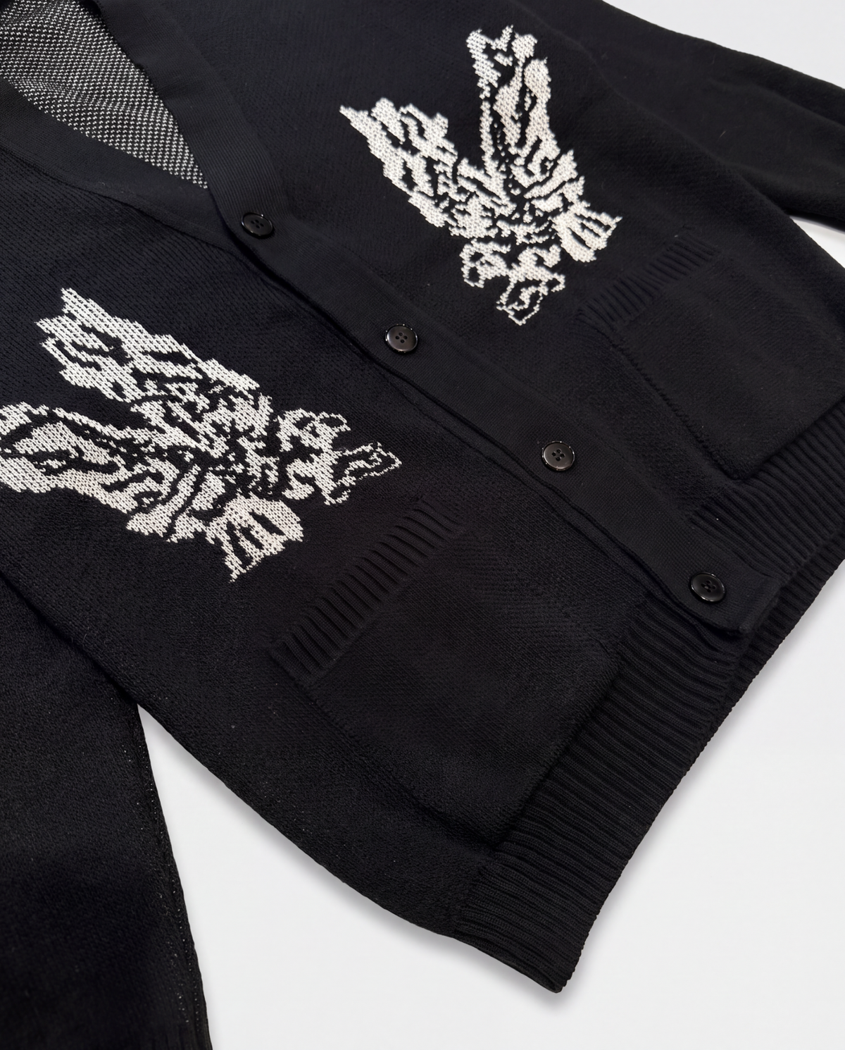 Dettaglio cardigan nero ARCHIVE con motivi jacquard e tasche